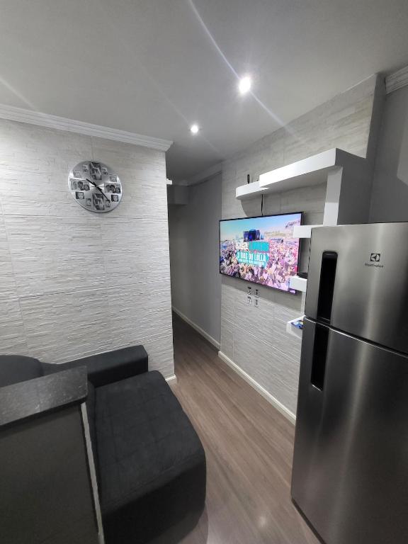 a kitchen with a refrigerator and a flat screen tv at Recanto de Paz Lapa - RJ in Rio de Janeiro