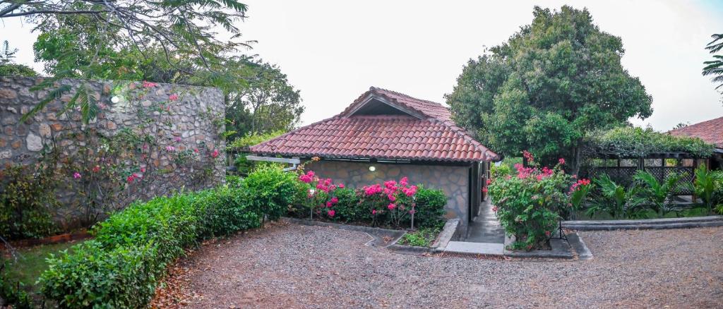 a house with a garden with flowers and a fence at Casa de Campo con Vista al Mar in Tubará