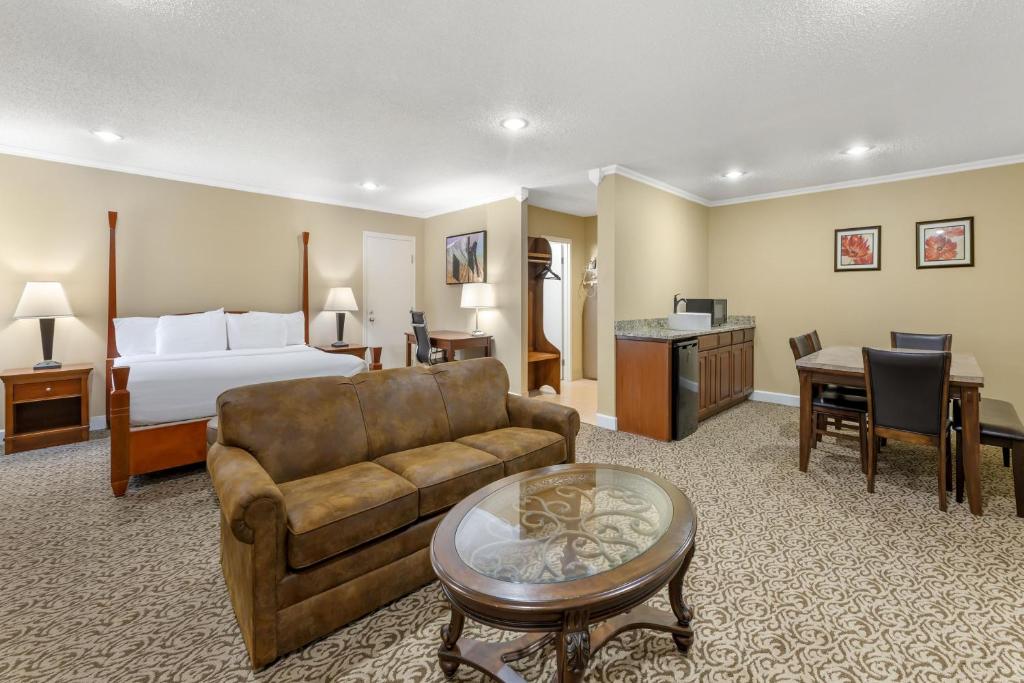 a hotel room with a bed and a couch and a table at Best Western Plus Wooster Hotel & Conference Center in Wooster
