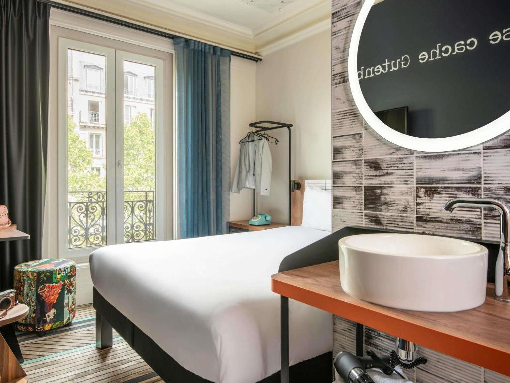 a hotel room with a sink and a mirror at Ibis Styles Hotel Paris Gare de Lyon Bastille in Paris
