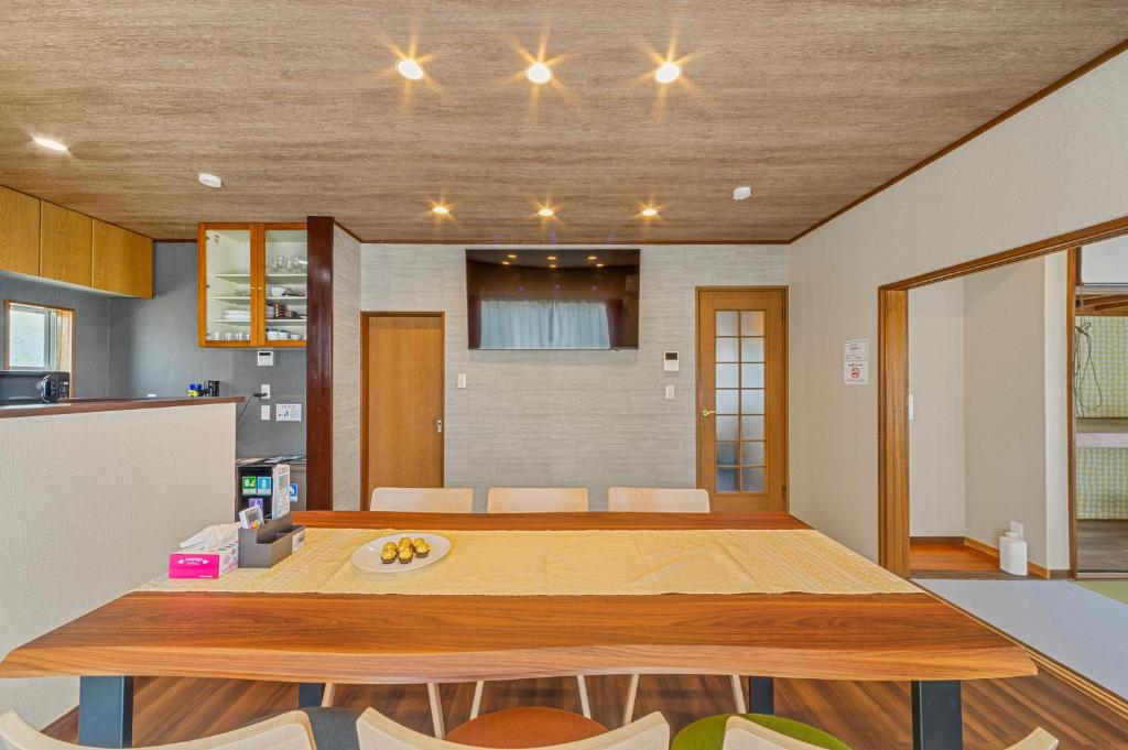 a kitchen and dining room with a large wooden table at Third Place Villa KISARAZU in Kisarazu