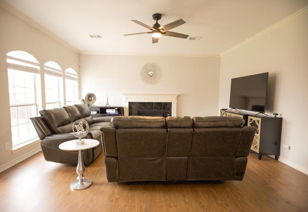 a living room with a couch and a ceiling fan at Pet friendly Spacious 4 Bedroom home with large, fenced backyard, located to DFW airport, restaurants and shops in Irving