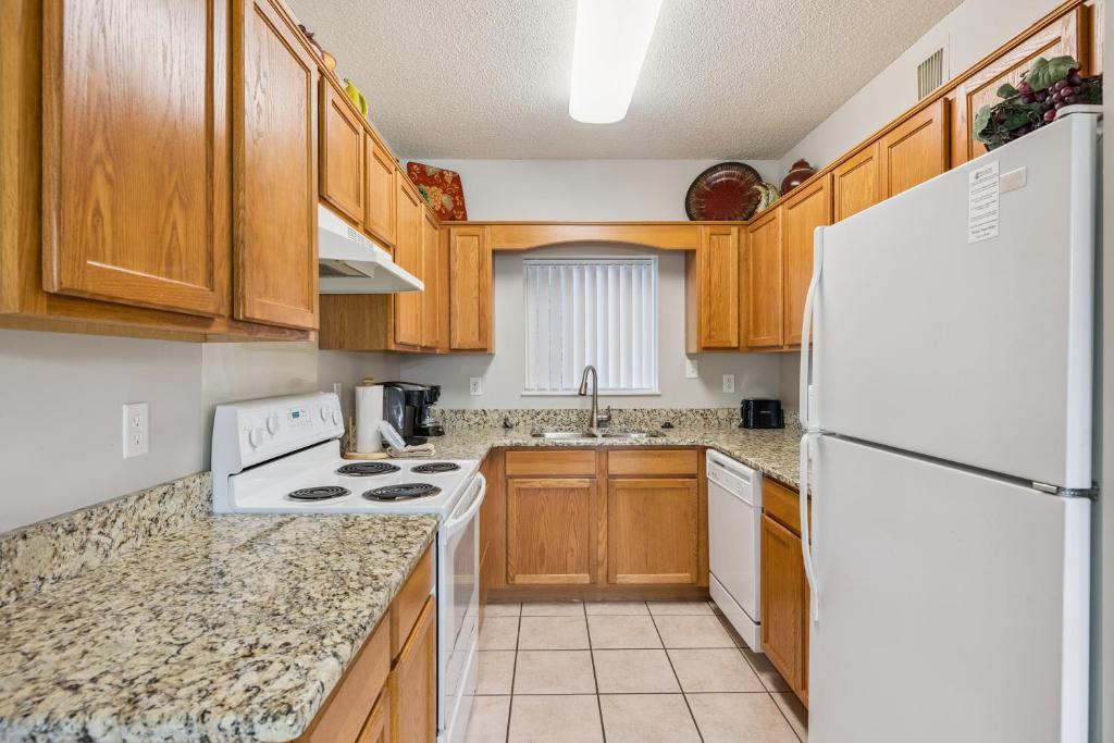 a kitchen with wooden cabinets and a white refrigerator at WP521 We've Got It All in Pigeon Forge