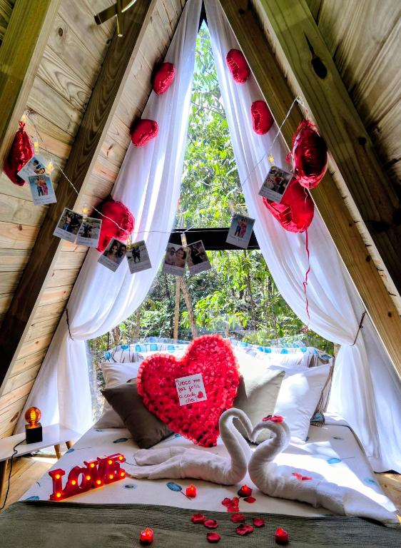 a bedroom with two hearts and two swans on a bed at Chales Holanda in Pirenópolis