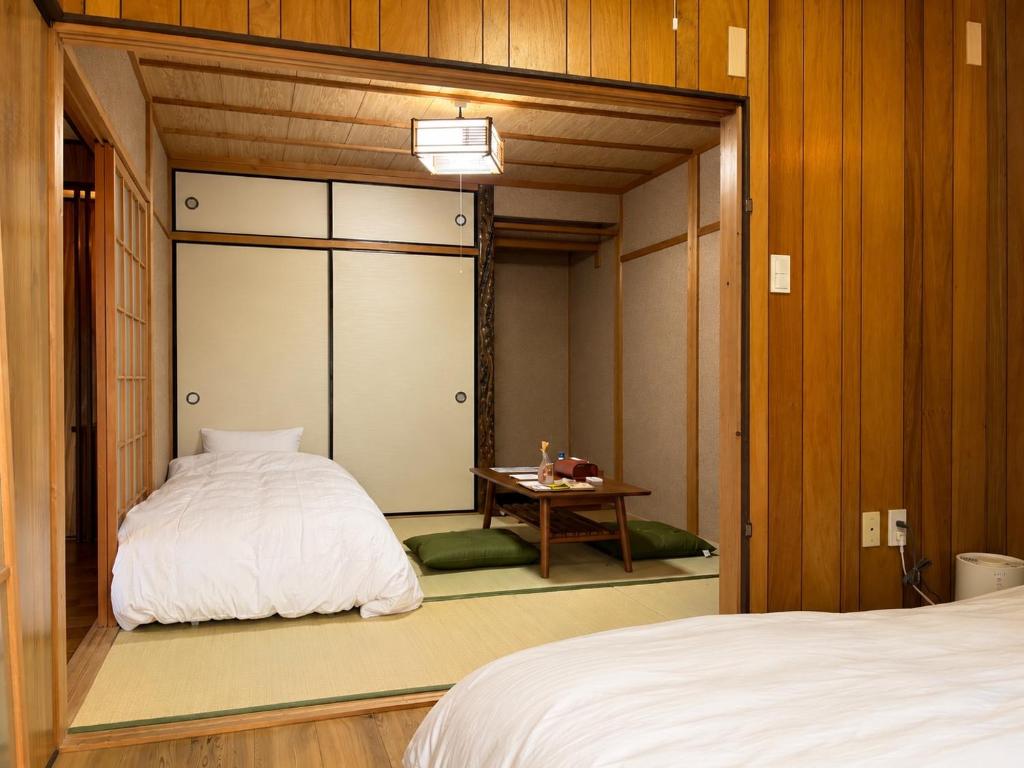 a small room with a bed and a table at KAMIKURA stay in Shingū