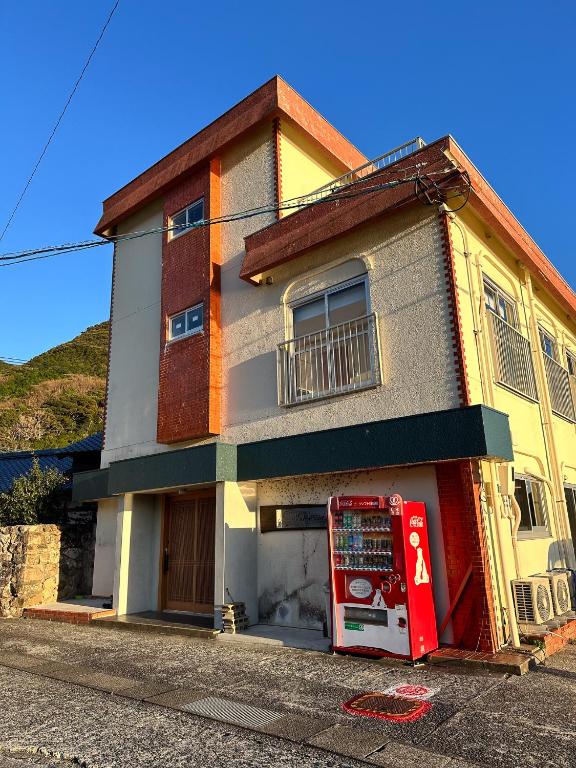 a house with a soda machine in front of it at ハーミットクラブ in Goto