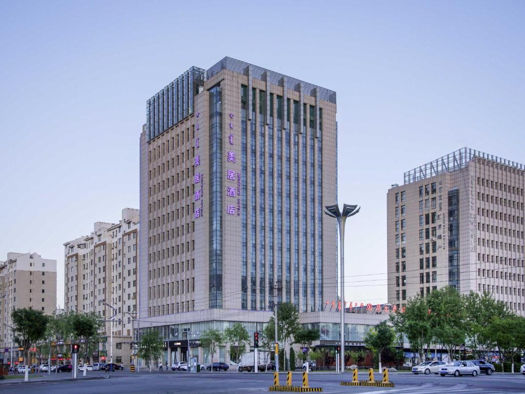 a tall building in a city with buildings at Mercure Ordos Downtown in Ordos