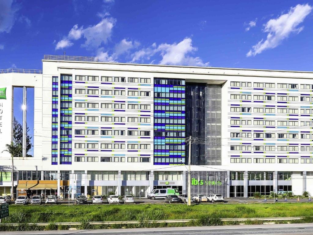 a large white building with cars parked in front of it at ibis Styles Confins Aeroporto in Lagoa Santa