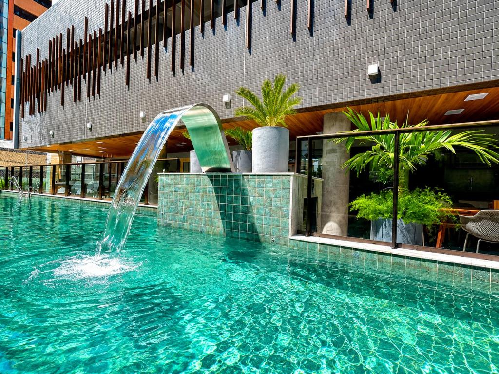 ein Schwimmbad mit Springbrunnen in einem Gebäude in der Unterkunft Std Design Mar in Maceió