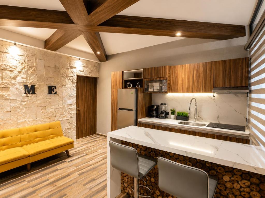 a kitchen with a white counter and a yellow couch at Divine Comfort in Villahermosa