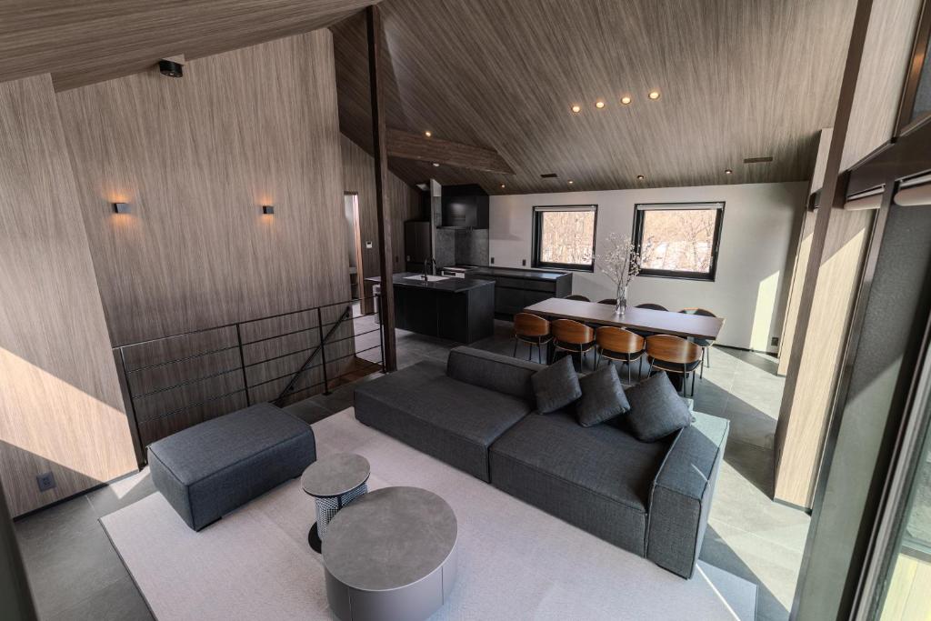 a living room with a couch and a kitchen at Forest Resort Walnut in Hakuba