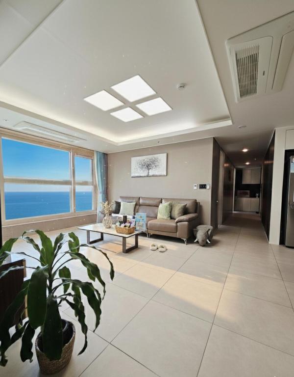 a living room with a couch and a table at 이스턴뷰 프리미엄 레지던스 100프로오션뷰 in Ulsan