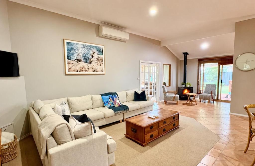 a living room with a couch and a coffee table at Coastal Haven on Sandpiper in Broadwater