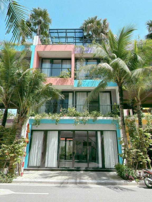 a building with palm trees in front of it at Villa Flamingo B109 in Thanh Hóa