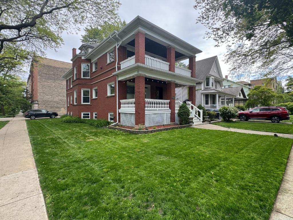 a large red brick house with a green yard at Elegant and Chic 2Bed 2Bath steps from the lake! in Chicago