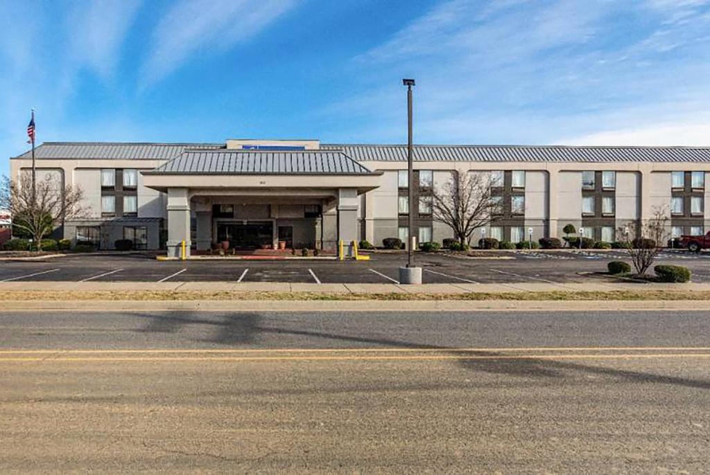 a building with a parking lot in front of it at Wingate by Wyndham Conway AR in Conway