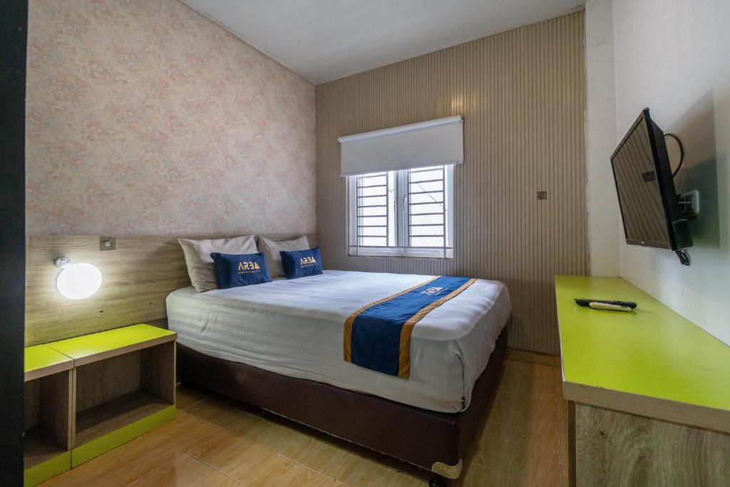 a bedroom with a large bed and a window at Hotel Dahlia By ARBA in Jakarta