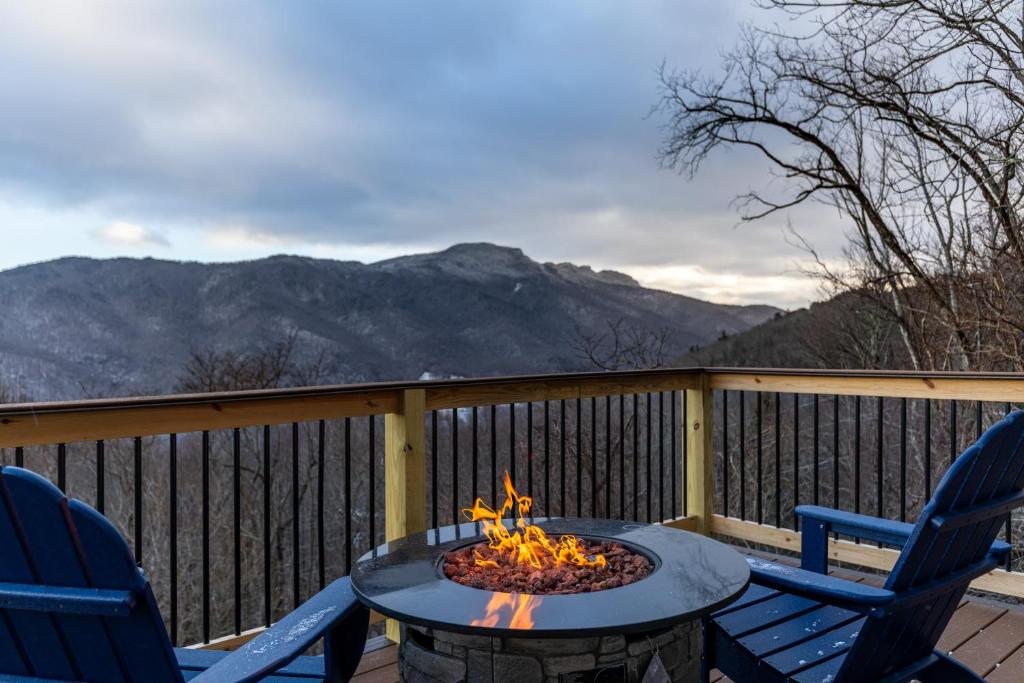 a fire pit on a deck with two chairs at Blue Ridge Vista in Seven Devils