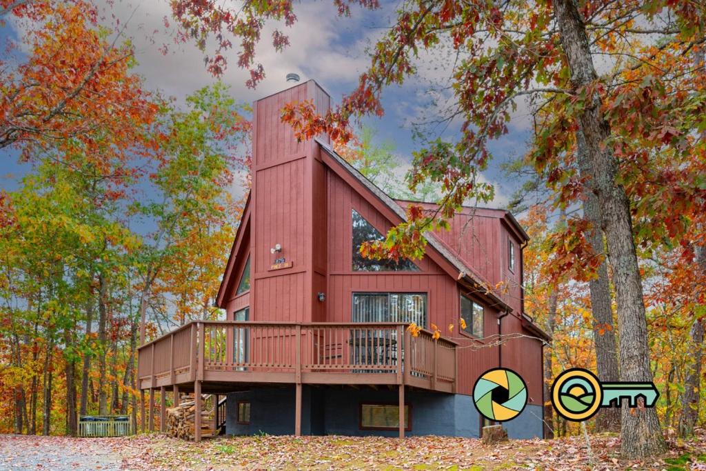 a red house with a deck in the woods at Villa #91 in Basye