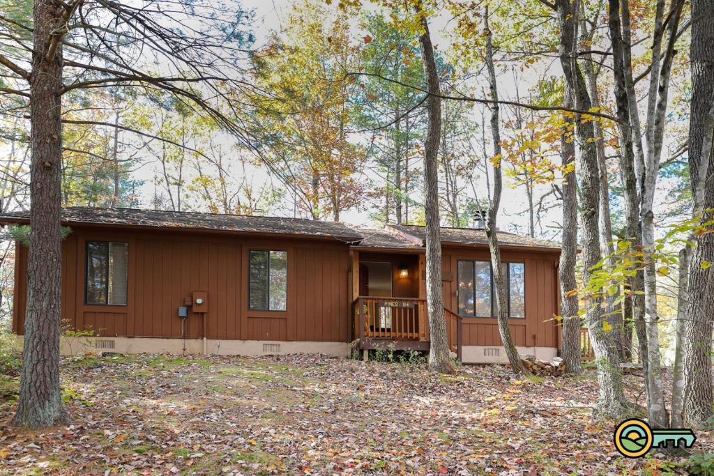 a house with a porch in the woods at Villa #114 in Basye