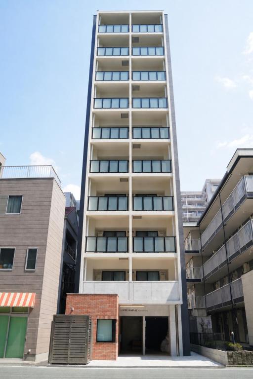 a tall apartment building in the middle of buildings at レジデグローバル熊本 in Kumamoto