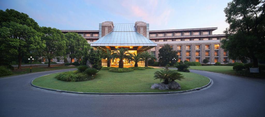 a building with a gazebo in the middle of a park at Shanghai Dongjiao State Guest Hotel in Shanghai