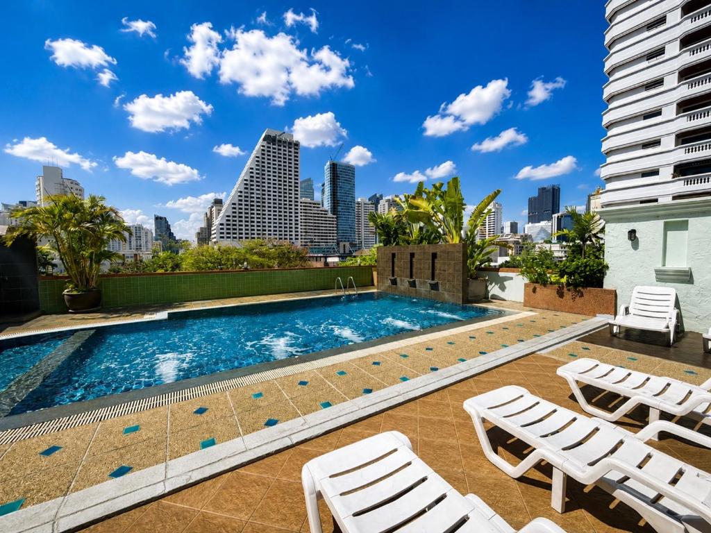 a swimming pool on the roof of a building with a city skyline at Woraburi Sukhumvit Hotel in Bangkok