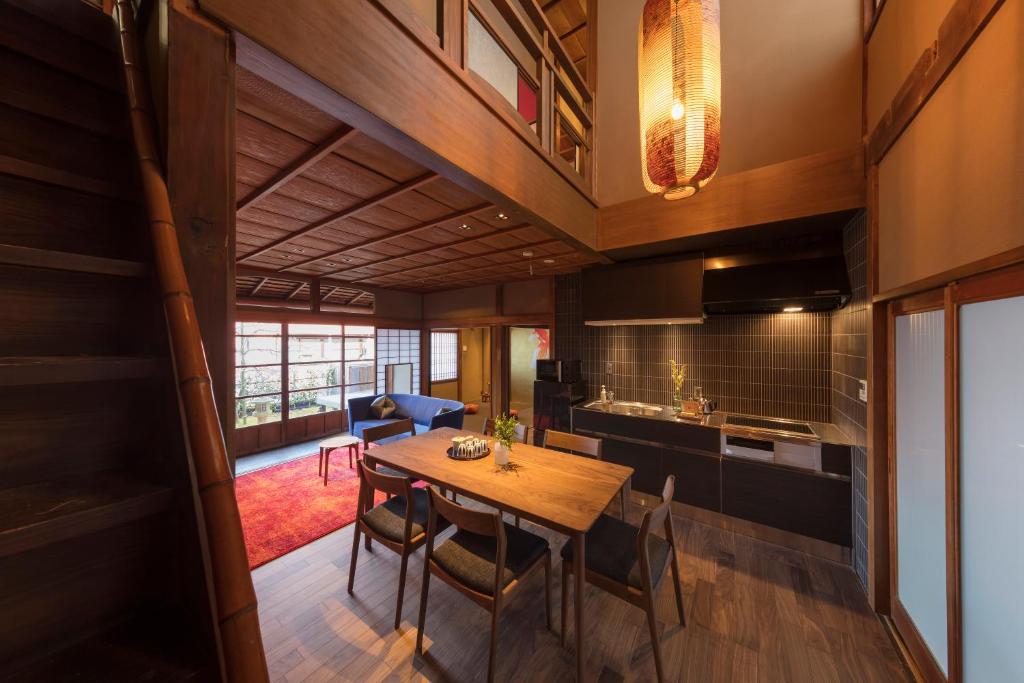 eine Küche und ein Esszimmer mit einem Holztisch und Stühlen in der Unterkunft Hikoso-machi Kin no Ma in Kanazawa