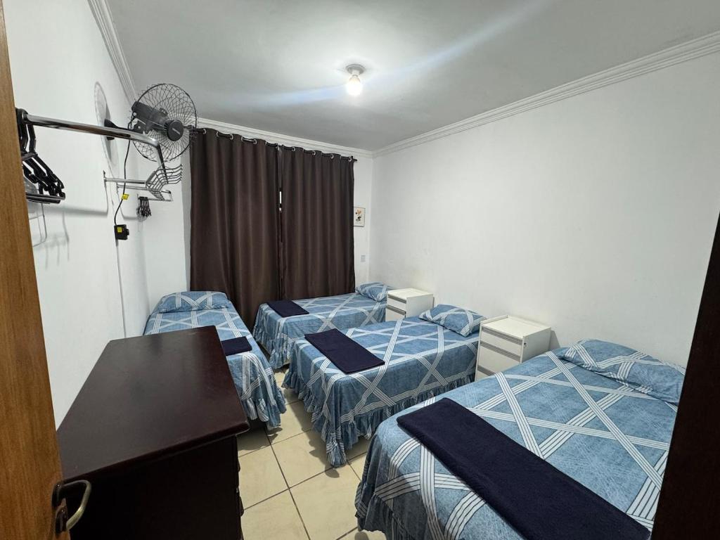 a room with two beds and a table in it at Casa 2 dorms com garagem e Wi-Fi in São Paulo