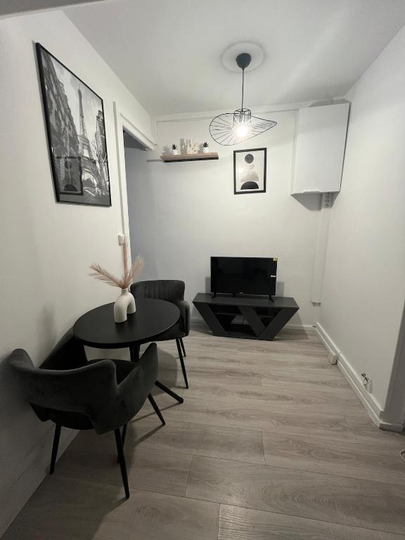 a living room with a table and a couch at Cocon 2 pièces - Design premium in Alfortville