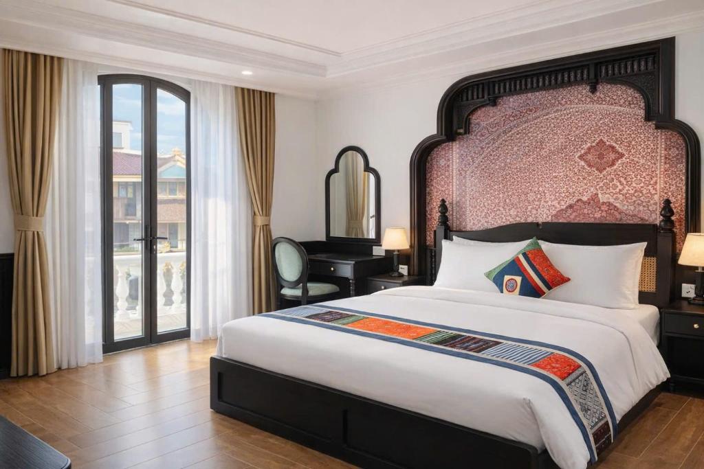 a bedroom with a large bed and a desk at Anara Sapa Hotel in Sapa
