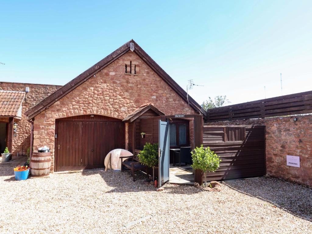 a large brick barn with a horse standing next to it at The Retreat in Watchet
