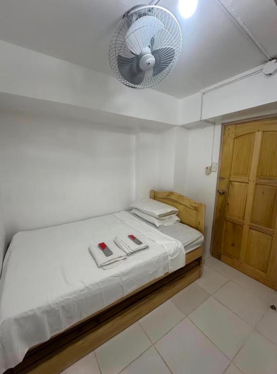 a small bedroom with a bed with a fan at RF Hotel Transient House in Bangued