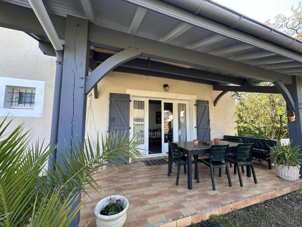 a patio with a table and chairs on it at Le gîte sabotier in Nerbis