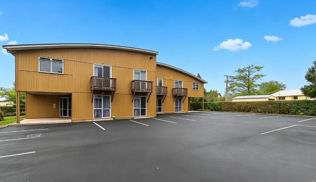 a building with a parking lot in front of it at Cube Lite Apartments in Hamilton