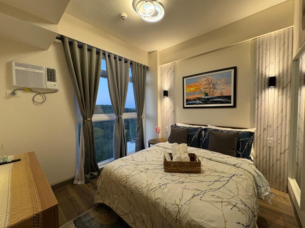 a bedroom with a bed and a large window at Ocean Garden Villas 7th Floor - Road Side in Boracay
