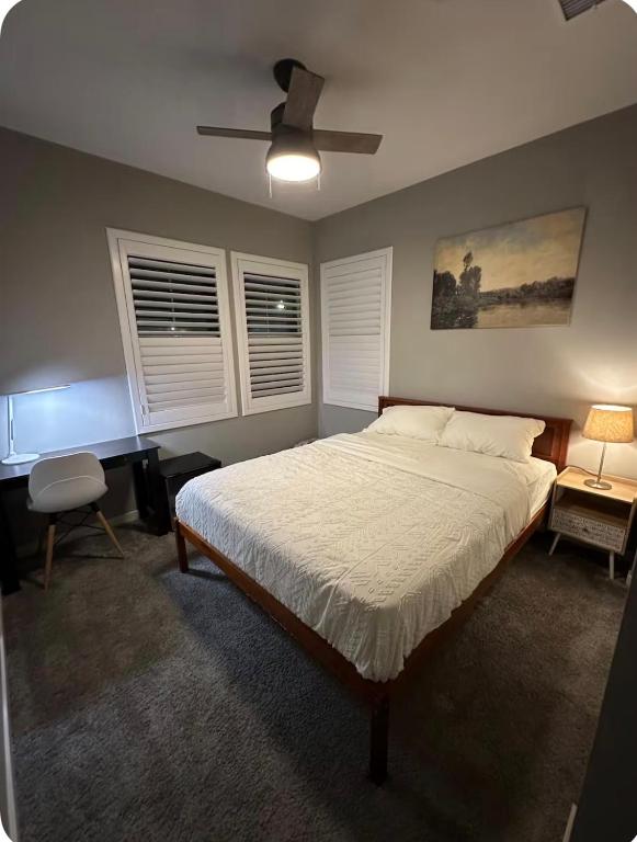 a bedroom with a bed and a desk and windows at Bright and Cozy Bay Window Cottage 6 in Ontario