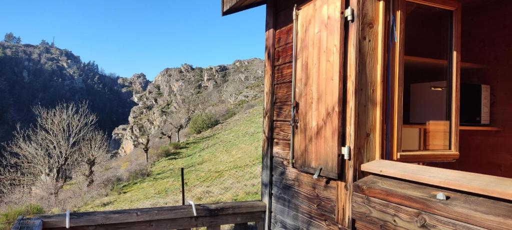 a window of a cabin with a view of a mountain at Chalet brumalis in Le Malzieu-Ville