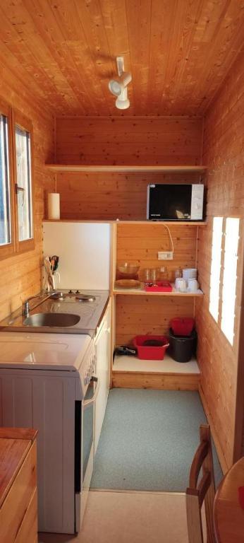 a small kitchen with a sink and a stove at Chalet rocenel in Le Malzieu-Ville