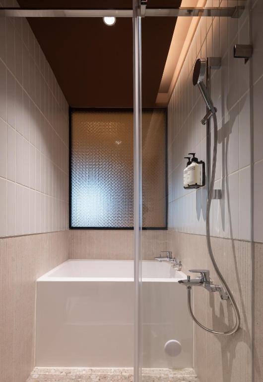 a bathroom with a shower and a tub and a sink at Boutech hotel Banqiao Yellowstone in Taipei