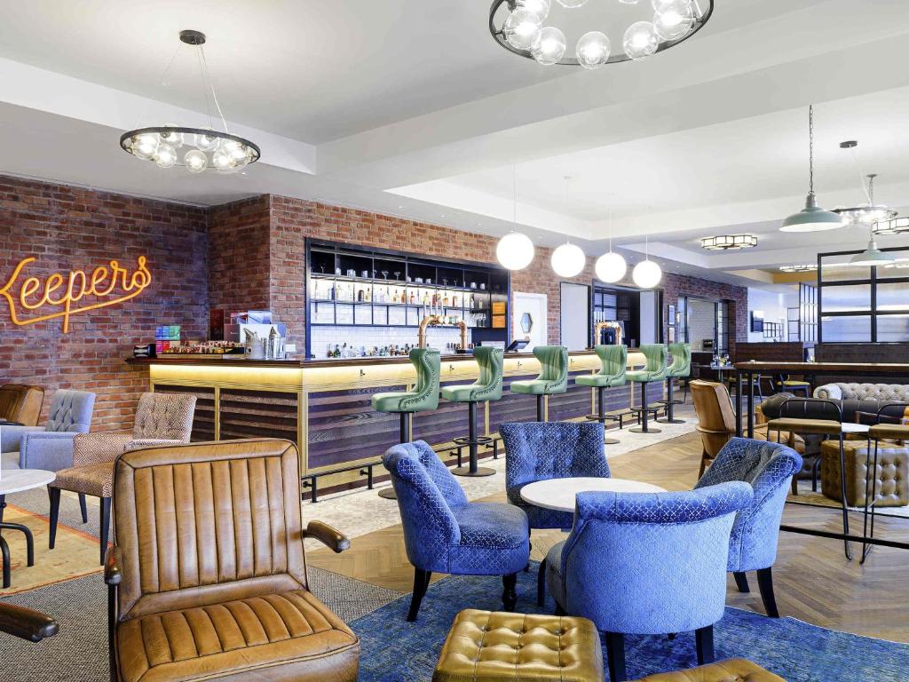 a restaurant with a bar with chairs and tables at ibis Bridgwater, M5 Jct23 in Bridgwater