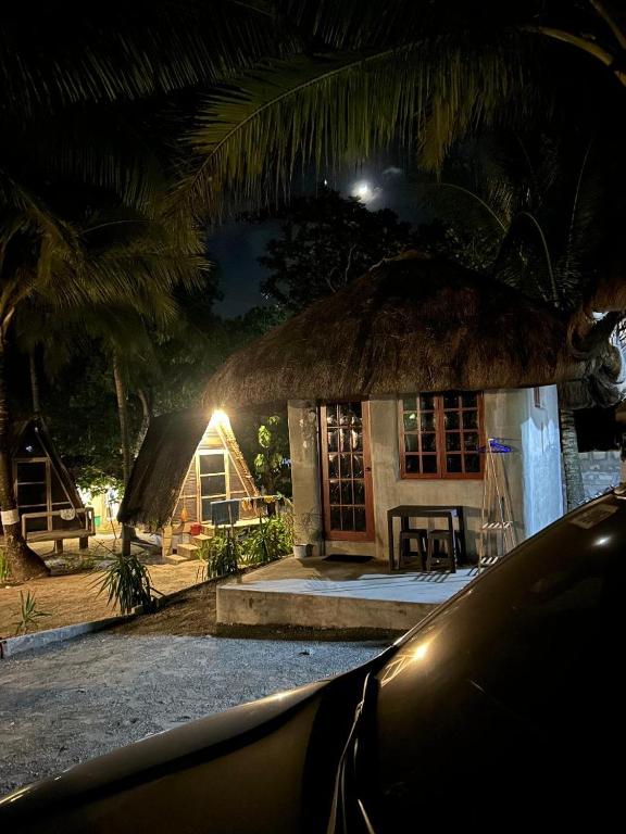 una piccola casa con il tetto di paglia di notte di Balituk a Baler