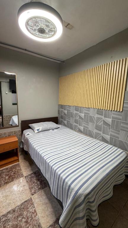 a bedroom with a large bed with a light at Hostal Arica 3 in Arica