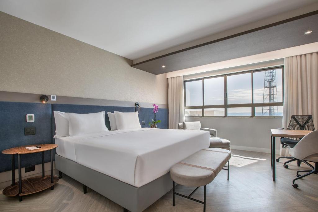 a large white bed in a room with a window at Meliá Brasil 21 in Brasília