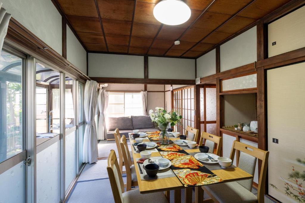 a dining room with a long table and chairs at オーシャンステイみうら in Miura
