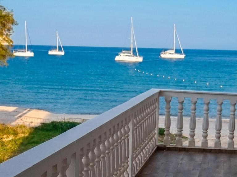 a balcony with a view of the ocean with boats at Marathon Studios & Apartments in Keri