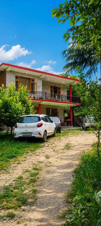 a white car parked in front of a house at Adarsh homestay - 1BHK in Manāli