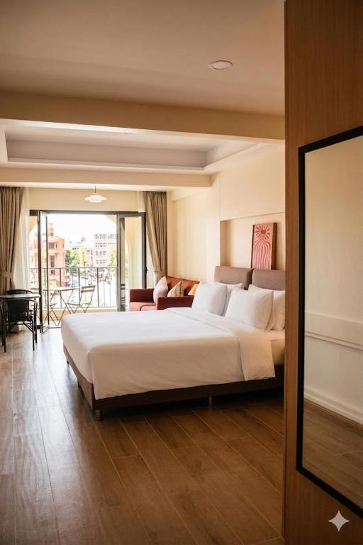a hotel room with a large bed and a balcony at An190 Boutique Hotel in Bangkok