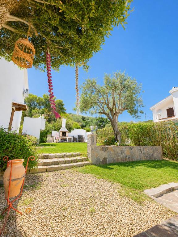 a garden with a tree and stairs and a house at SweetHouse Pula in Porto Columbu - Perdʼe Sali