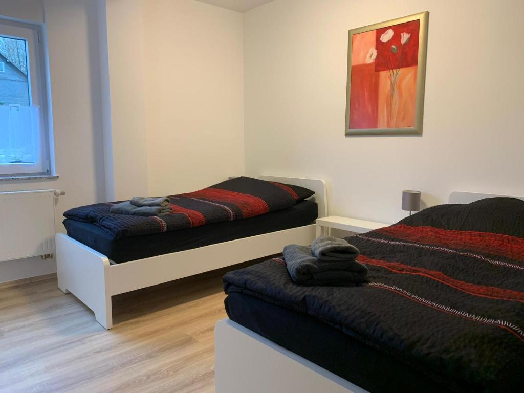 a bedroom with two beds and a painting on the wall at Schöne Ferienwohnung bei Lennestadt in Kirchhundem